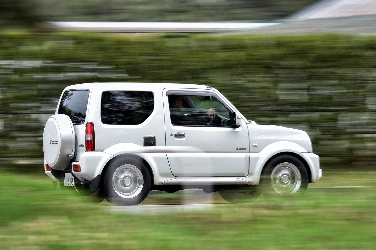 Four wheel drive towing a caravan up a climb through the Otways in summer with dust across the paintwork